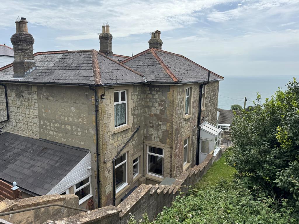Lot: 101 - SEMI-DETACHED HOUSE FOR IMPROVEMENT WITH SEA VIEWS - A Rear and Side View with the Sea Beyond